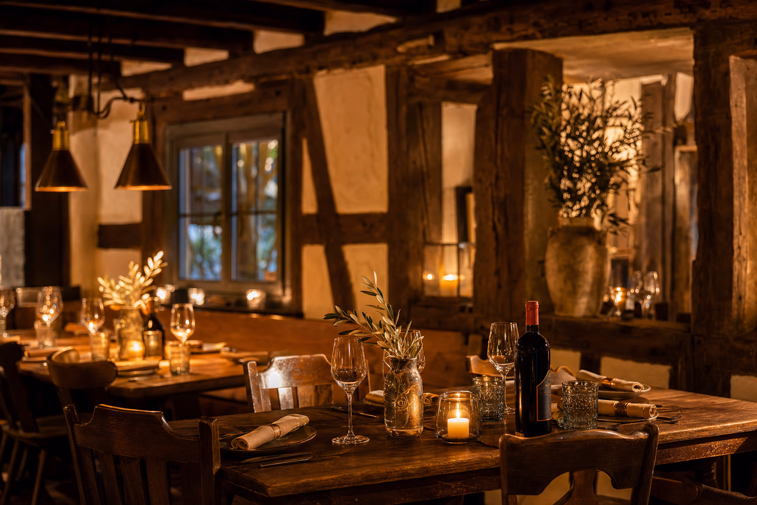 Warm beleuchtete Gaststube des Wirtshaus zum Ochsen mit gedeckten Holztischen